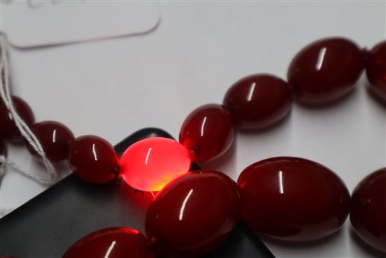 A single strand graduated simulated cherry amber necklace, gross weight 95 grams,